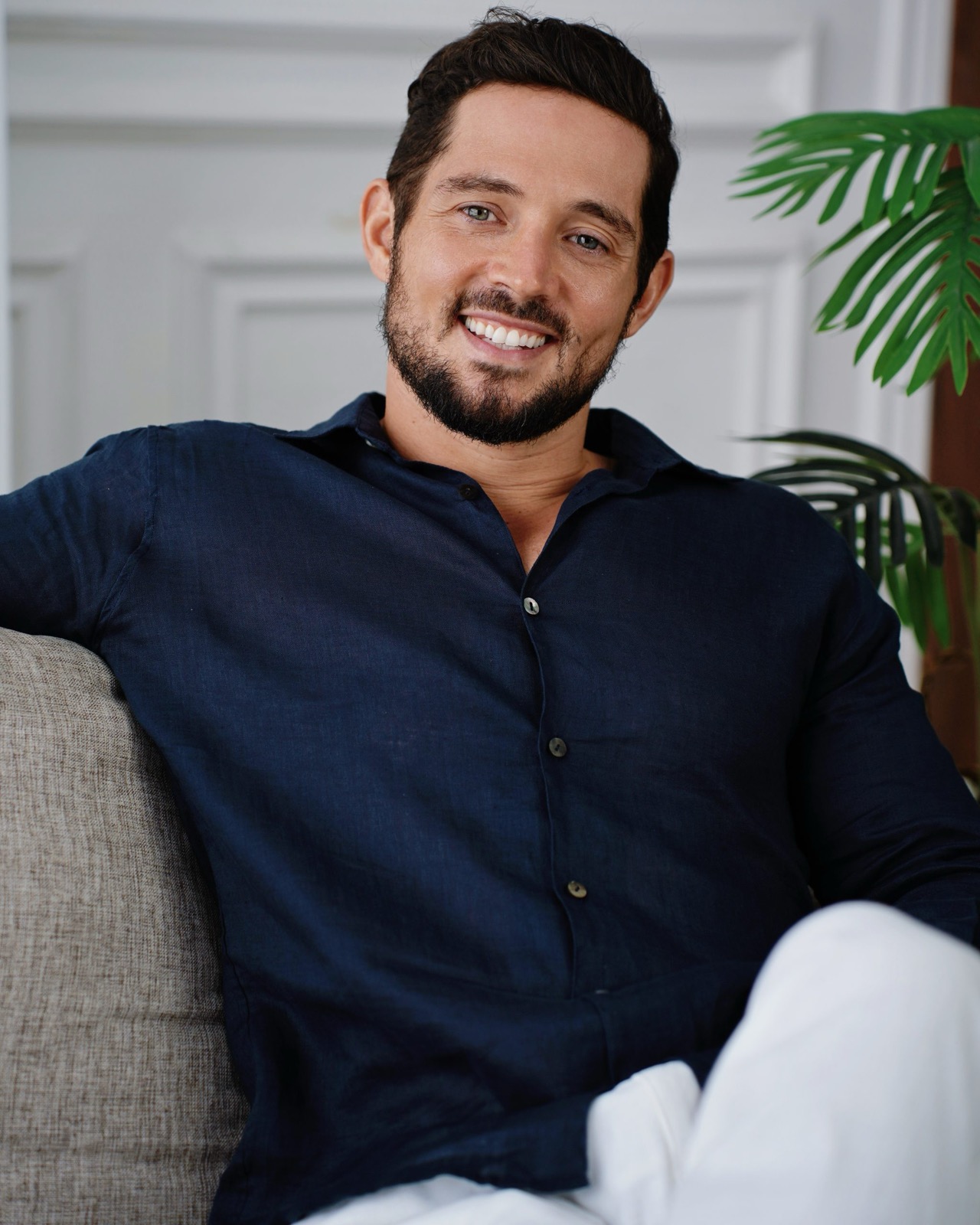 Zach Baughan, smiling, in a dark blue linen shirt